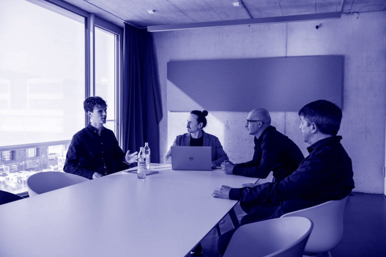 Moritz Bappert und Lennart Schleifer besprechen mit Kunden im Konferenzraum das neue WordPress-Webdesign
